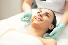 Young Lady Smiling While Cosmetologist Using Peeling Brush