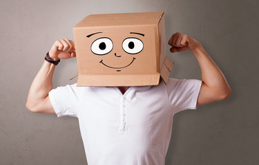 Young boy standing and gesturing with a cardboard box on his head
