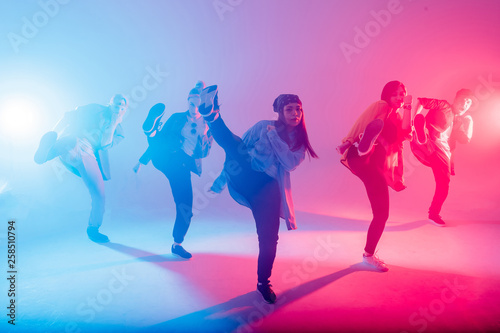 Group of diverse young hip-hop dancers in studio with special lighting ...