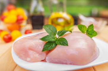 Raw chicken fillet and vegetables prepared for cooking on the kitchen.