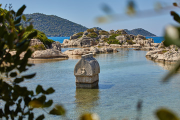 Coast of the island in the Mediterranean sea, picturesque with the ruins of ancient Lycian towns and tombs-sarcophagi of Aperlai, Simena Teimussa Dolihiste.