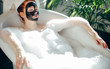 © alfa27 - Skin care - Young lady with facial black clay mask applyed on her face relaxing in foam bath, getting rejuvenation spa and beaty procedure at home