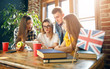© proimagecontent - Group of students sitting at the desk, looking at the tablet and doing homework