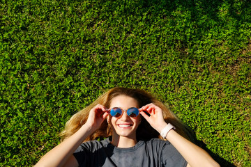 Portrait of young beautiful woman in tropical destination park with greenery on the background. Joy of summer holidays concept. Close up, copy space.