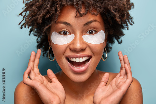 Fotomural Headshot of ovejoyed beautiful woman reduces under eye puffiness, dark circles,