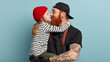 © WHstudio Leushin N - Photo of lovely girl and her father touch noses and kiss, have good relationships. Small daughter in fashionable clothes expresses love to dad, embraces affectionately. Ginger friendly family indoor