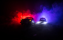 Police Car Chasing A Car At Night With Fog Background. 911 Emergency Response Police Car Speeding To Scene Of Crime. Selective Focus
