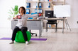 © Elnur - Middle-aged female employee doing exercises in the office