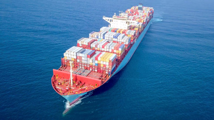 Ultra large container vessel (ULCV 366 Meters long) loaded with various Container brands, at sea - Aerial image.