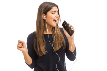 Wall Mural - Female Hipster Singing Against Plain Background