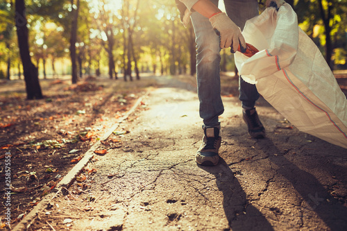 Fotomural young man picking up trash outdoor. close up