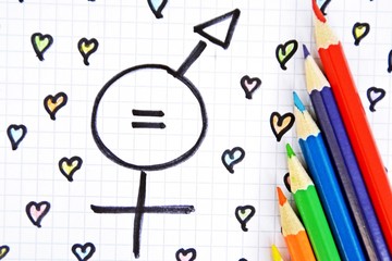 Wall Mural - A sign for the equality of man and woman consisting of the respective gender signs and a match with painted hearts and colored pencils on a drawn sheet -equality man and woman symbolically represented