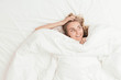 © TheCreativeBrigade - Happy Blonde Woman Under White Duvet Covers