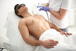 © Yakobchuk Olena - Female making laser epilation of chest to man