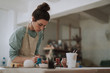 © Yakobchuk Olena - Beautiful young woman in apron working in pottery workshop