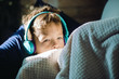 © danr13 - A close up of a boy in headphones, covered with a blanket