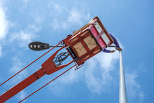 Technician On Bucket Truck High Up Of A Crane To Fix Street Light.