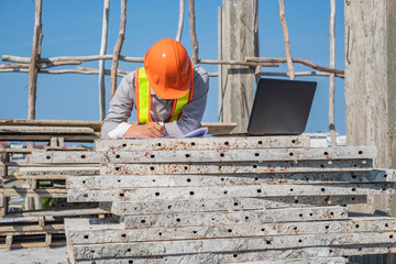 Engineer using laptop at construction sit.