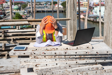 Stress engineer or architect with laptop and tablet holding hands at his head. He is having problems in work. Engineering concept.