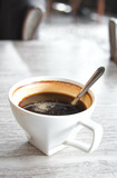 Fototapeta Sawanna - A cup of coffee with small spoon on table.