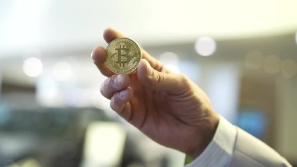 Aufkleber - Businessman hand holding glowing bitcoin sign. Stock. Virtual money concept and Financial growth concept on chart background. Hand of a businessman holding a coin bitcoin