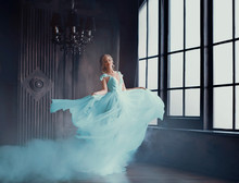 The Magical Transformation Of Cinderella Into A Beautiful Princess In A Luxurious Dress. Young Women Are Blonde, Spinning And Dancing In A Dark, Gloomy Room, The Dress Fluttering On The Fly. Art Photo