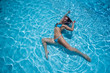© Михаил Решетников - Over head rear view of an attractive young woman swimming under water and wearing in bikini