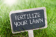 Chalkboard in the grass with fertilize your lawn