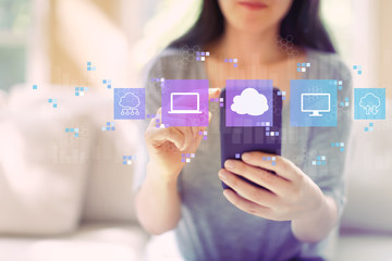 Wall Mural - Cloud computing with woman using her smartphone in a living room