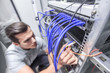 © alotofpeople - Man working in network server room