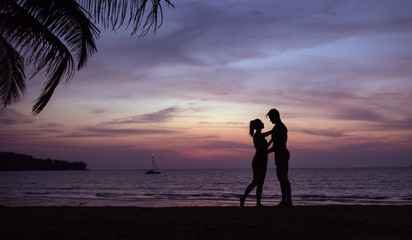 Wall Mural - Romantic portrait of a couple hugging on a tropical brach - sunset circumstance