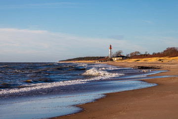 Wall Mural - an old lighthouse stands on the shore of the sea