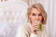 © zinkevych - Blonde-haired woman drinking healthy green juice in bedroom