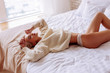 © zinkevych - Woman wearing white panties and beige sweater chilling in bed