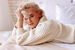 © zinkevych - Appealing young woman with wavy hair wearing beige sweater