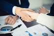 © rogerphoto - Business people shaking hands finishing up a meeting. Handshake at successful negotiation