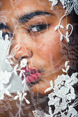 Wall Mural - portrait of beauty young afro woman through white lace, like new bride under veil close up