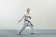 © andreyfire - In karategi, a male athlete does formal karate exercises on a gray cover