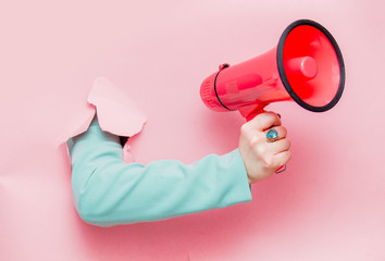 female hand in classic blue jacket with megaphone