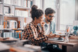 © Dusan Petkovic - Two multicultural students studying for exams and using laptop while sitting in library. In background shelves with books.