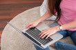 © weedezign - Happy asian woman typing on laptop computer at home.female freelancer sitting on carpet on floor work at home in living room.