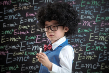 Primary School Boy Standing In Front Of The Blackboard