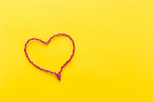 Pink Wire Heart Shaped On Yellow Background