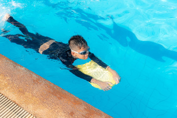 Boys are swimming in the pool.