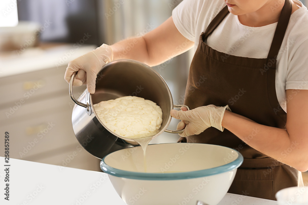 Woman preparing tasty cheese in kitchen