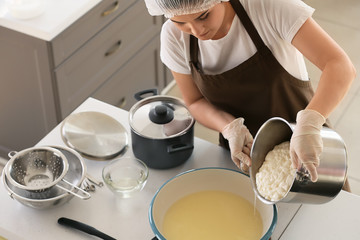 Woman preparing tasty cheese in kitchen