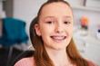 © gpointstudio - Portrait of smiling child with braces in dentist's office