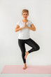 © Alexandr - stylish elderly woman doing yoga on a white background