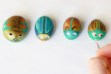 Painted Stones Handmade As Beetles On A White Background