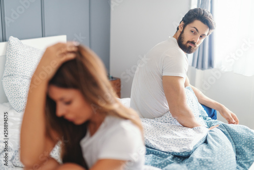 Sad Woman Sitting On The Bed In Bedroom In The Morning And